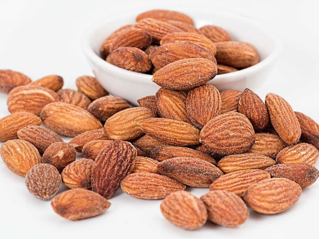 A pile of almonds on a white table.