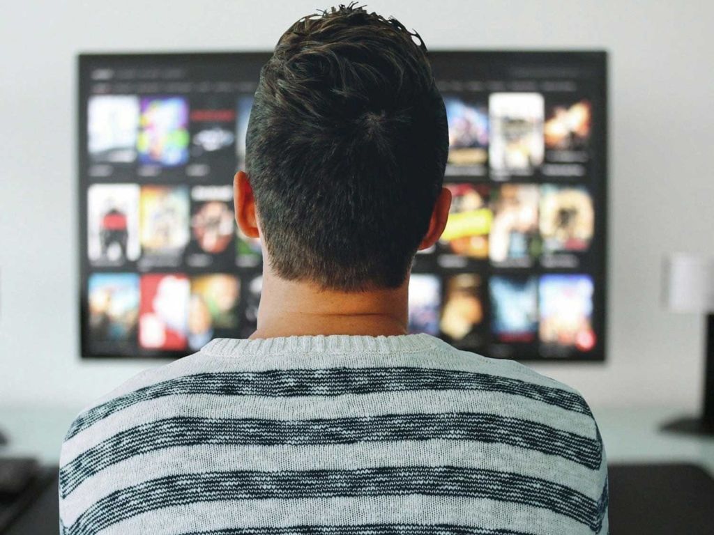 Man sitting in front of a 4k TV.