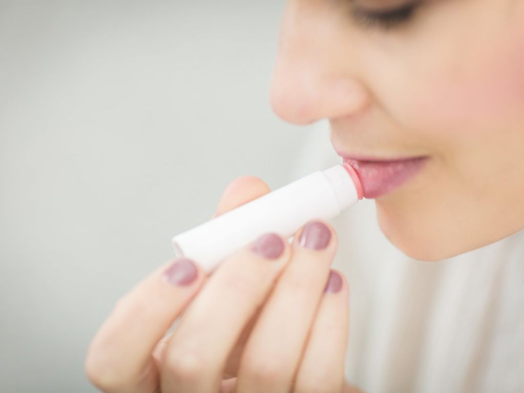 Woman applying lip balm