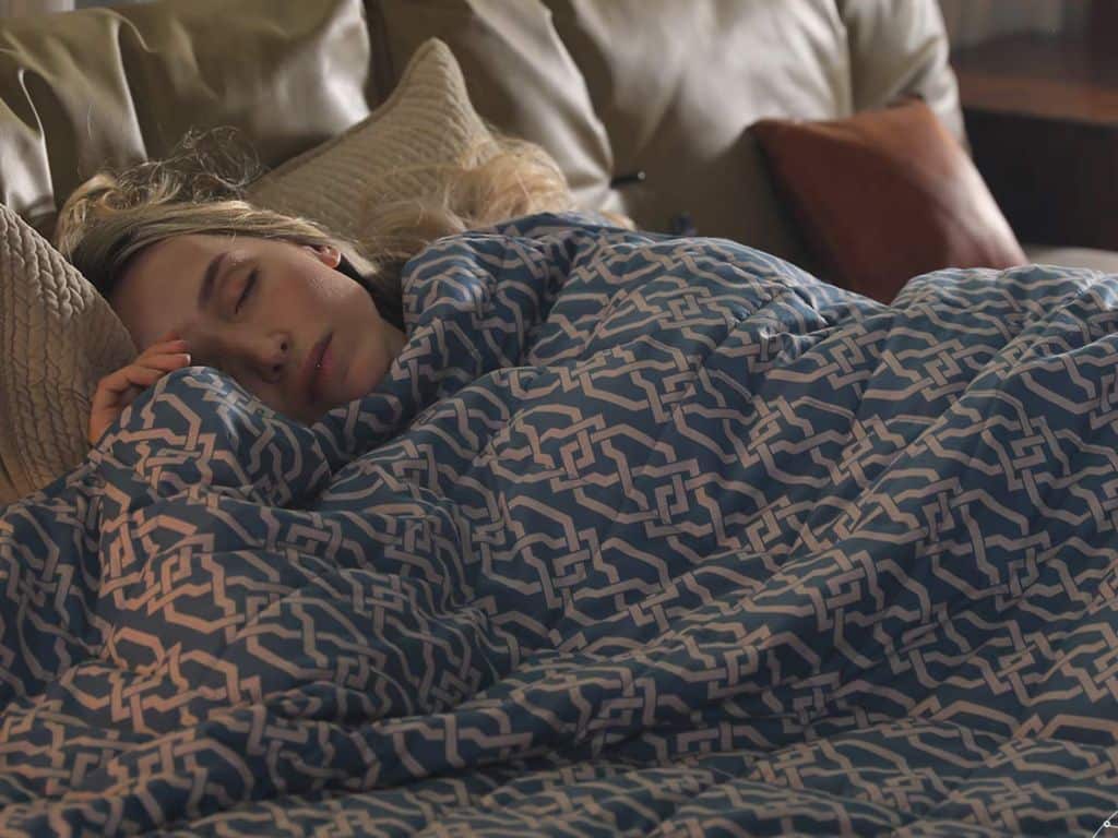Woman sleeping under a weighted blanket