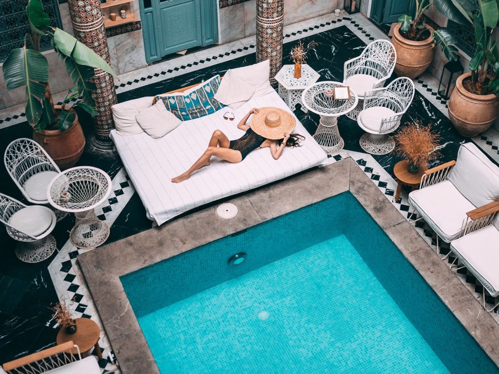 Woman laying on a pool cabana.