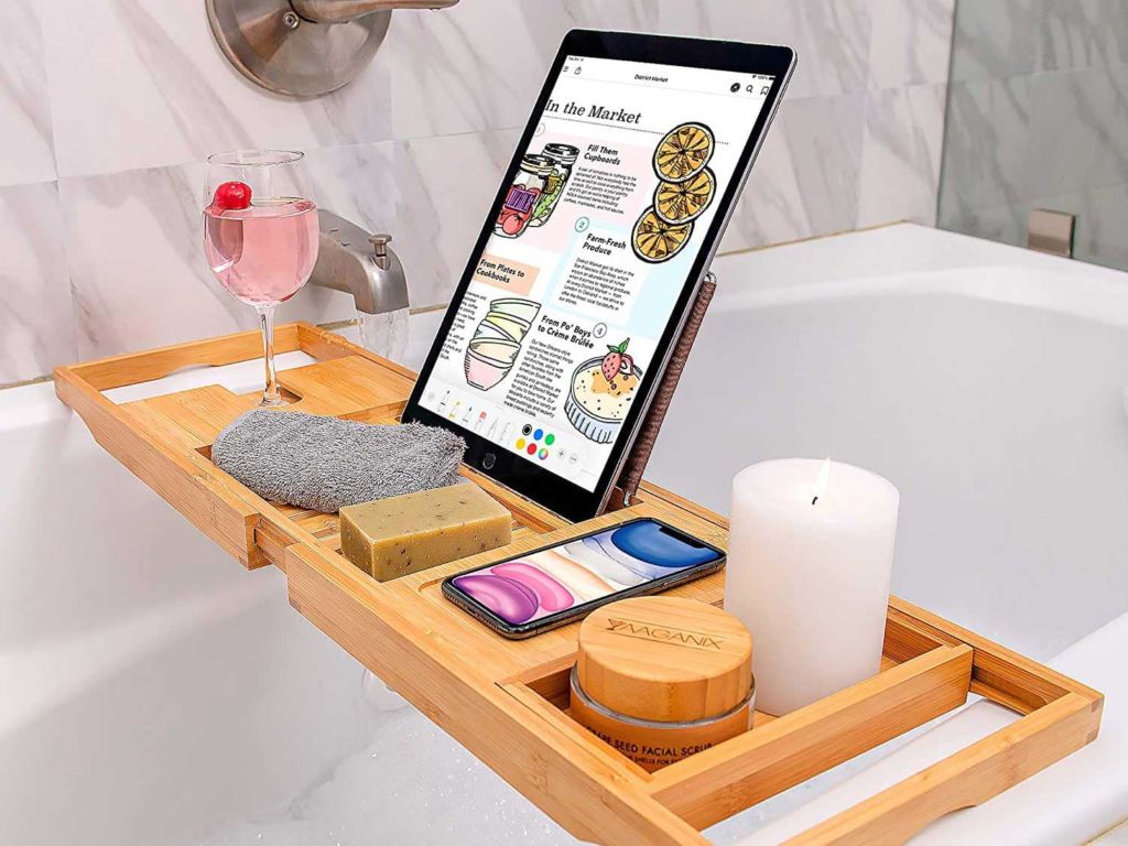 Tablet and candles on a bathtub caddy.