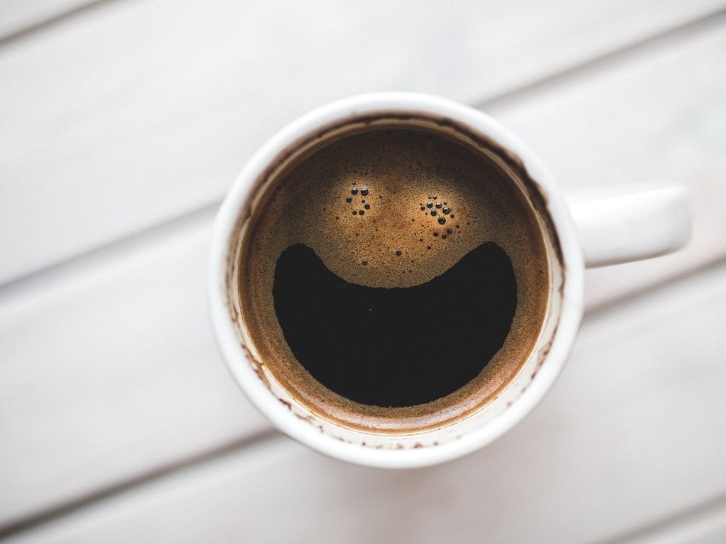 Cup of hot coffee with a smiley face
