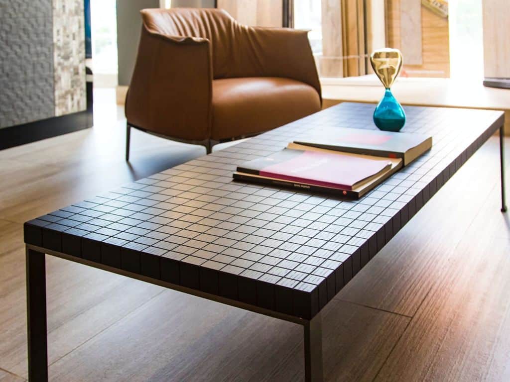 Coffee table covered with magazines and a flower pot.