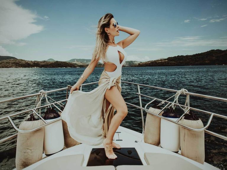 Woman on a boat wearing a swimsuit cover up.