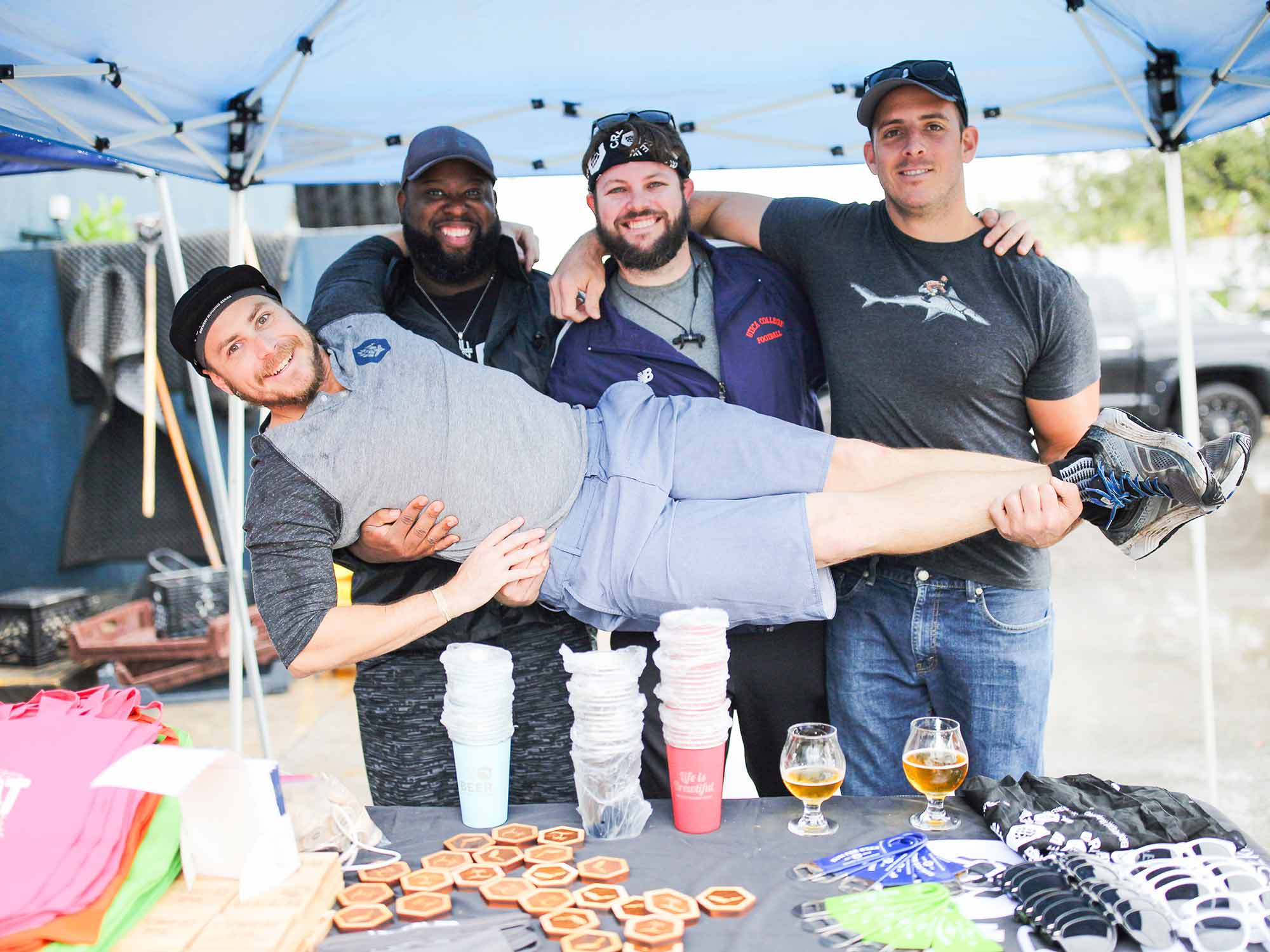 Three guys holding up another guy