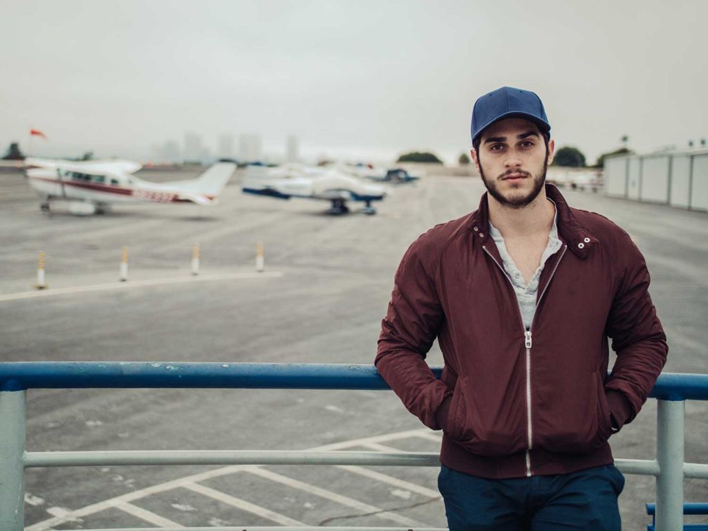 Man wearing a flight jacket at an airport
