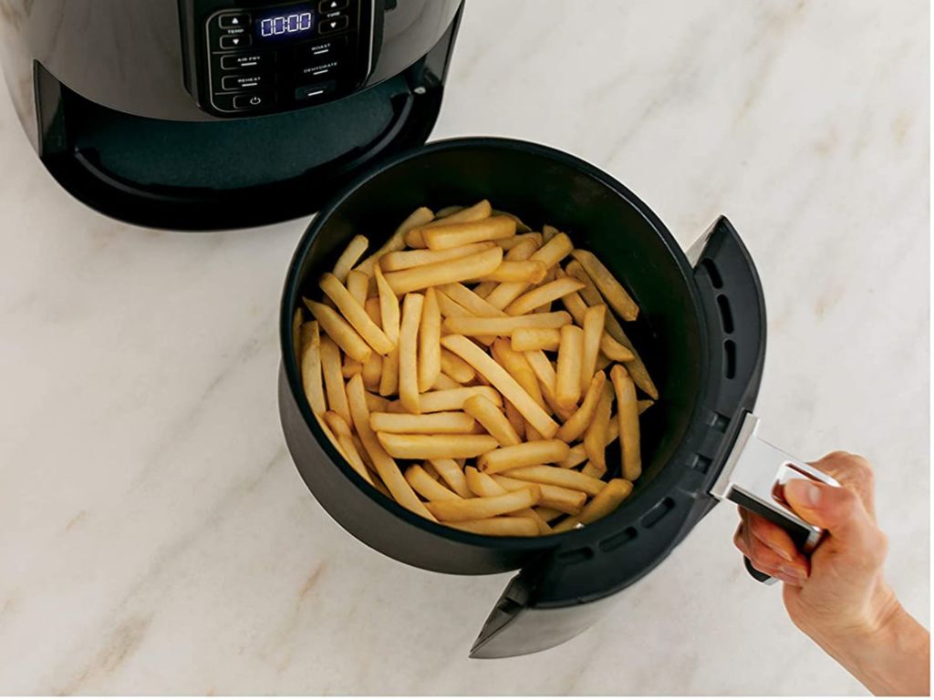 Man cooking french fries in an air fryer