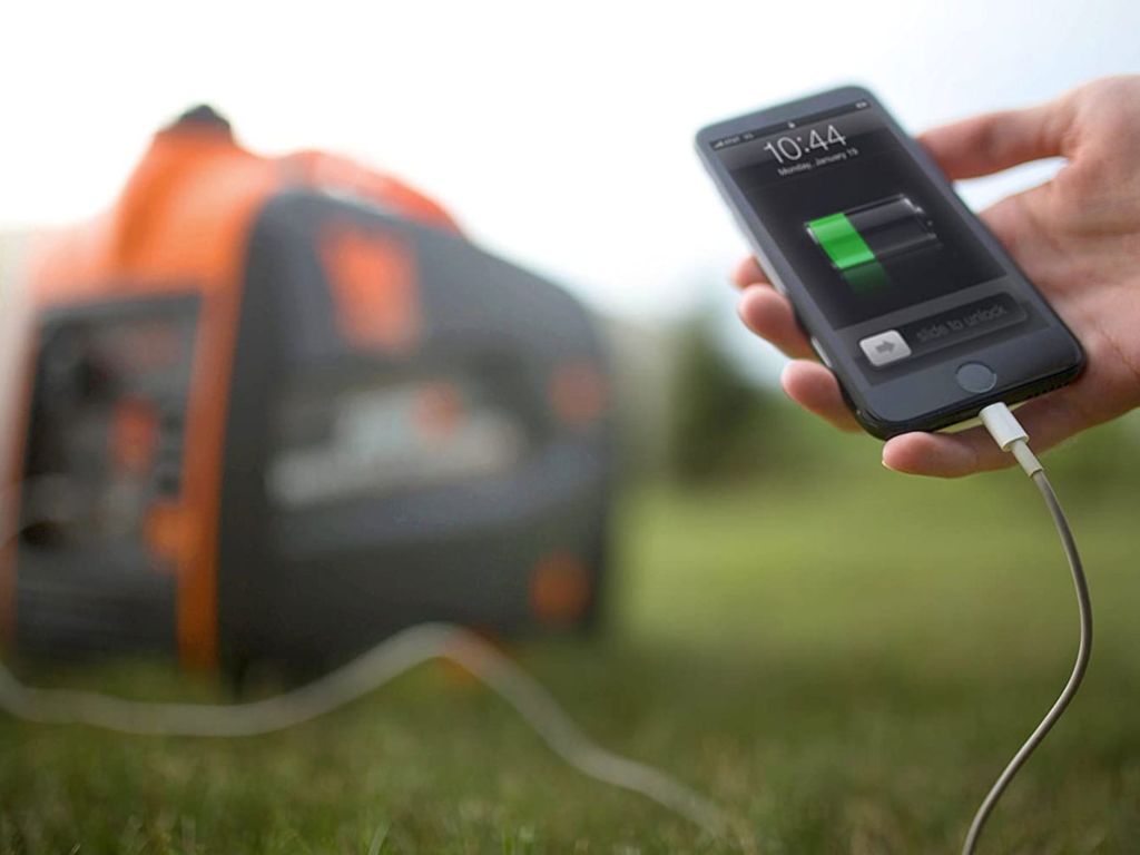 Man charging a smart phone with a power generator.