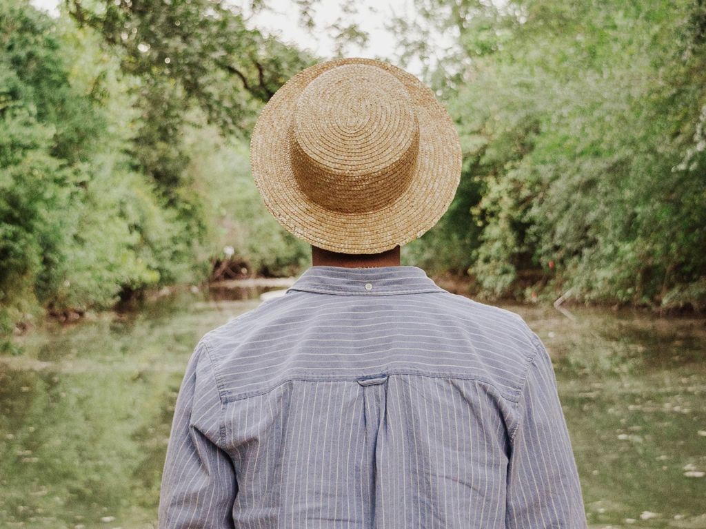 Man in sun hat standing in the woods