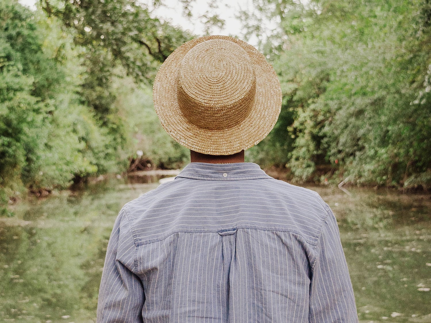 Man in sun hat standing in the woods