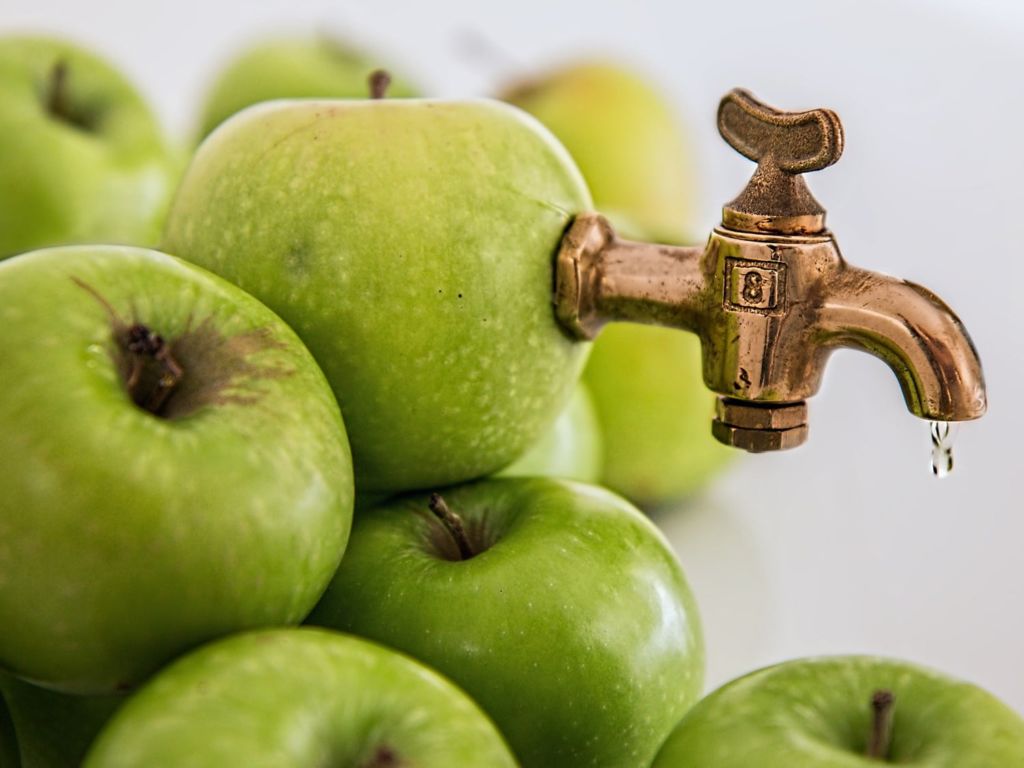 Apples with a faucet stuck inside.