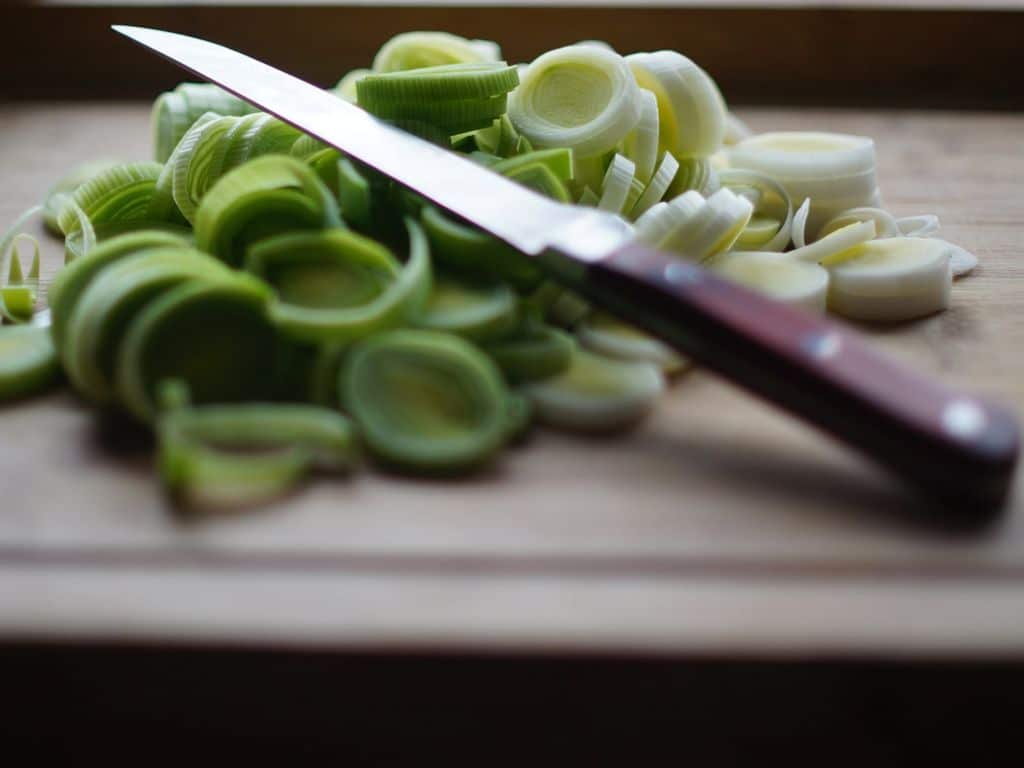 Knife sitting on top of cut vegetables