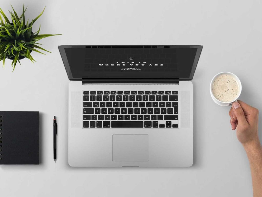 Man using a laptop computer while drinking coffee.