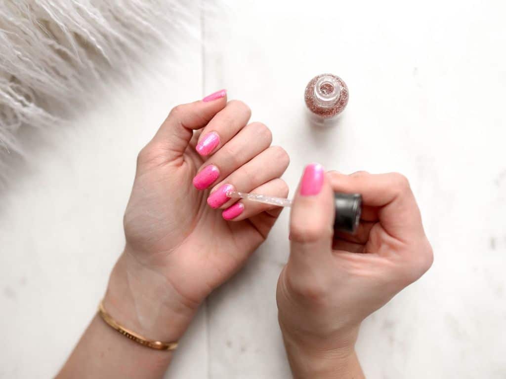 Woman giving herself a manicure.