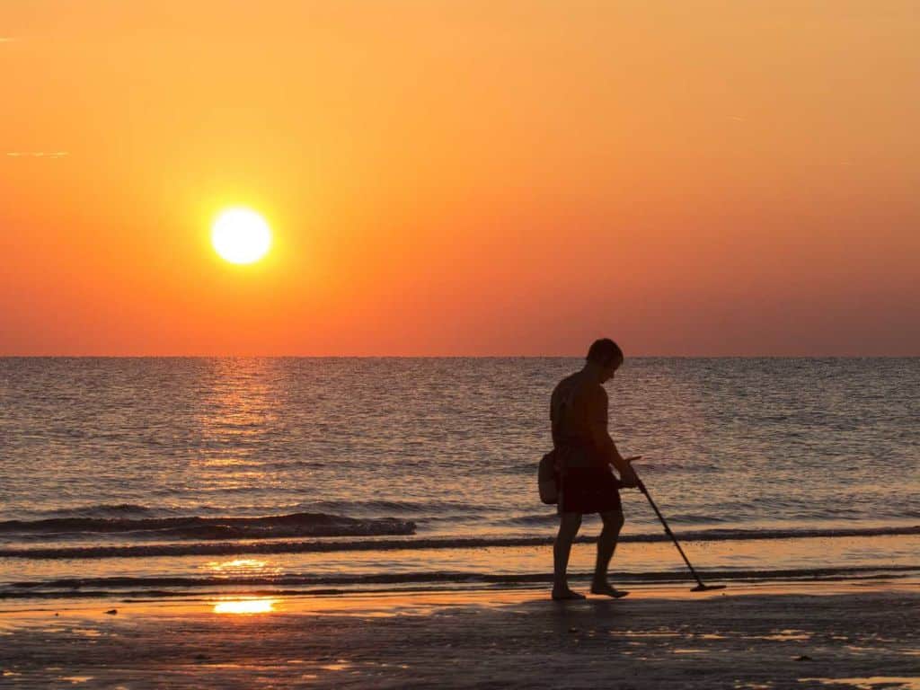 Man using a metal detector at the beach