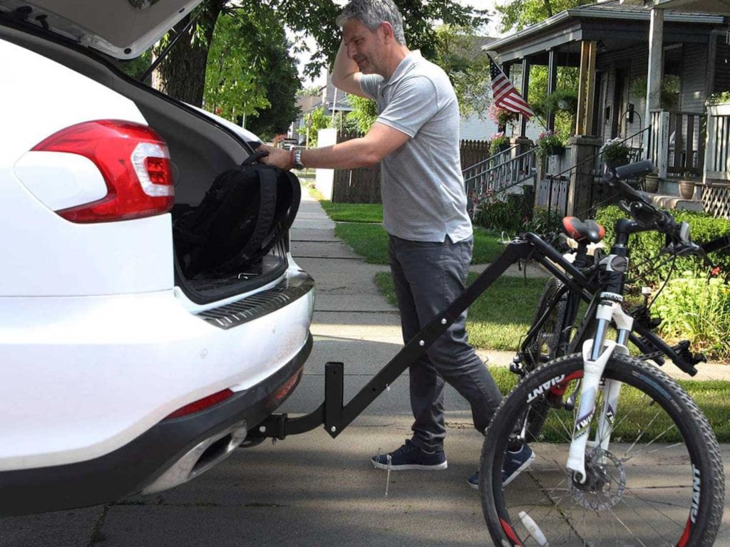 Man mounting a bike on his vehicle.
