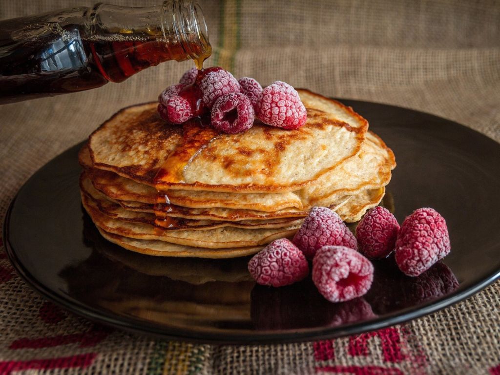 Stack of pancakes with fruit and syrup on top