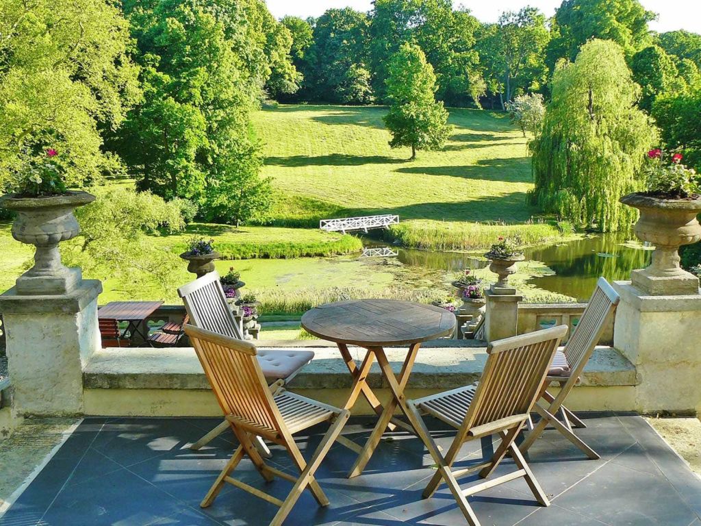 Chairs on a patio overlooking a big yard.