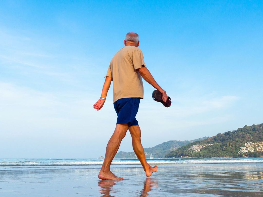 Man walking barefoot on a beach