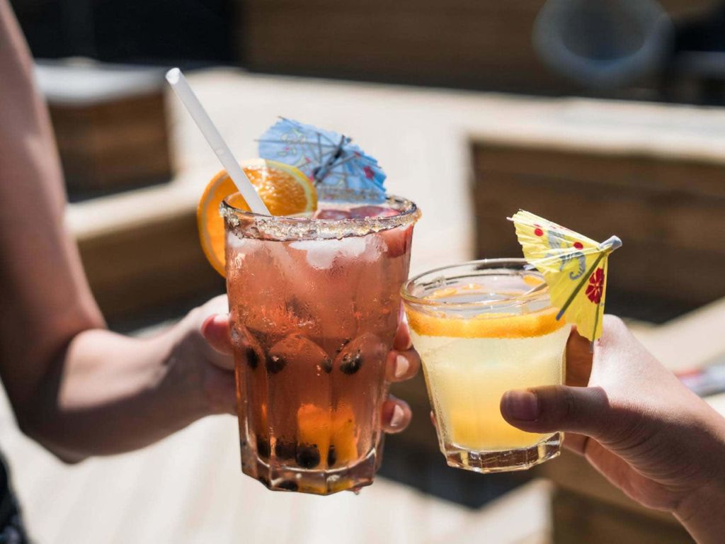 Two adults toasting drinks