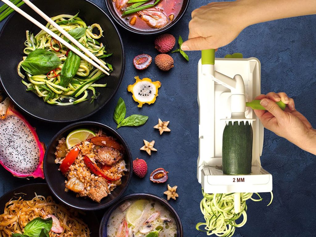 A vegetable spiralizer in action with dishes shown.