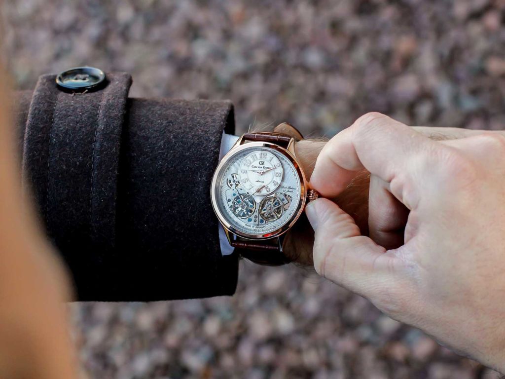 Man adjusting a watch outdoors.
