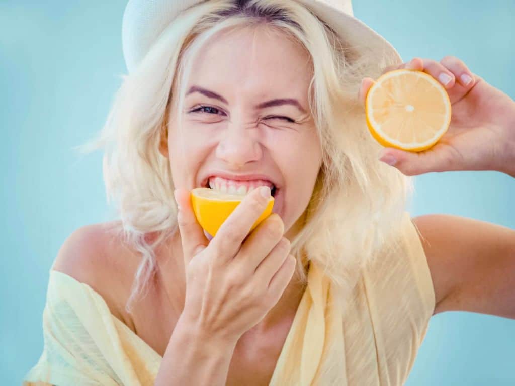 Woman biting lemon