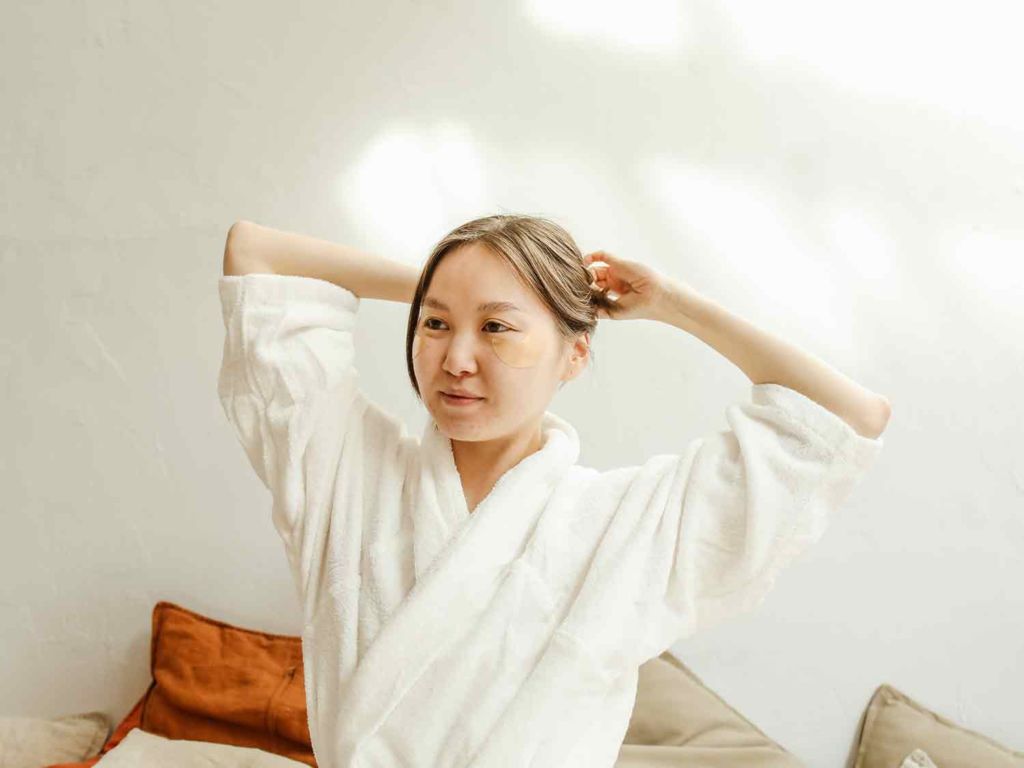 Woman wearing robe doing morning routine.