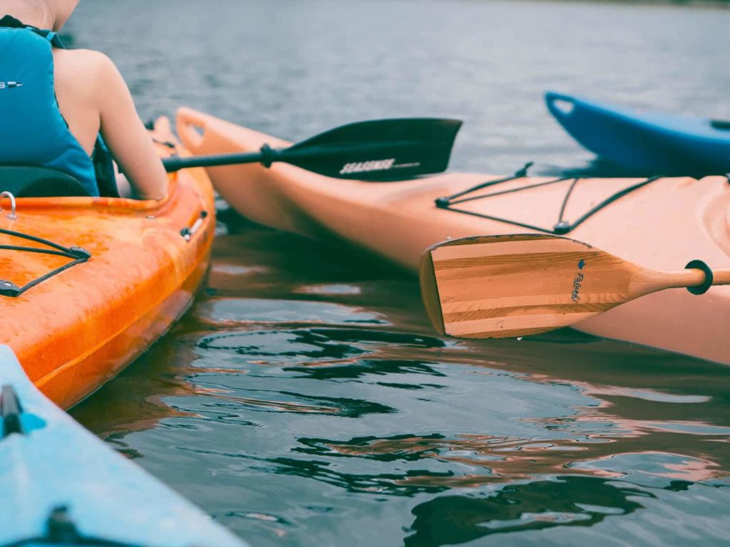 People in kayaks paddling into the water