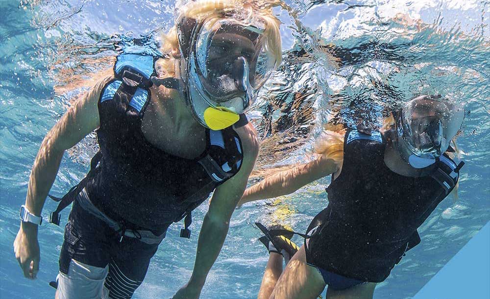 two snorkelers wearing vests