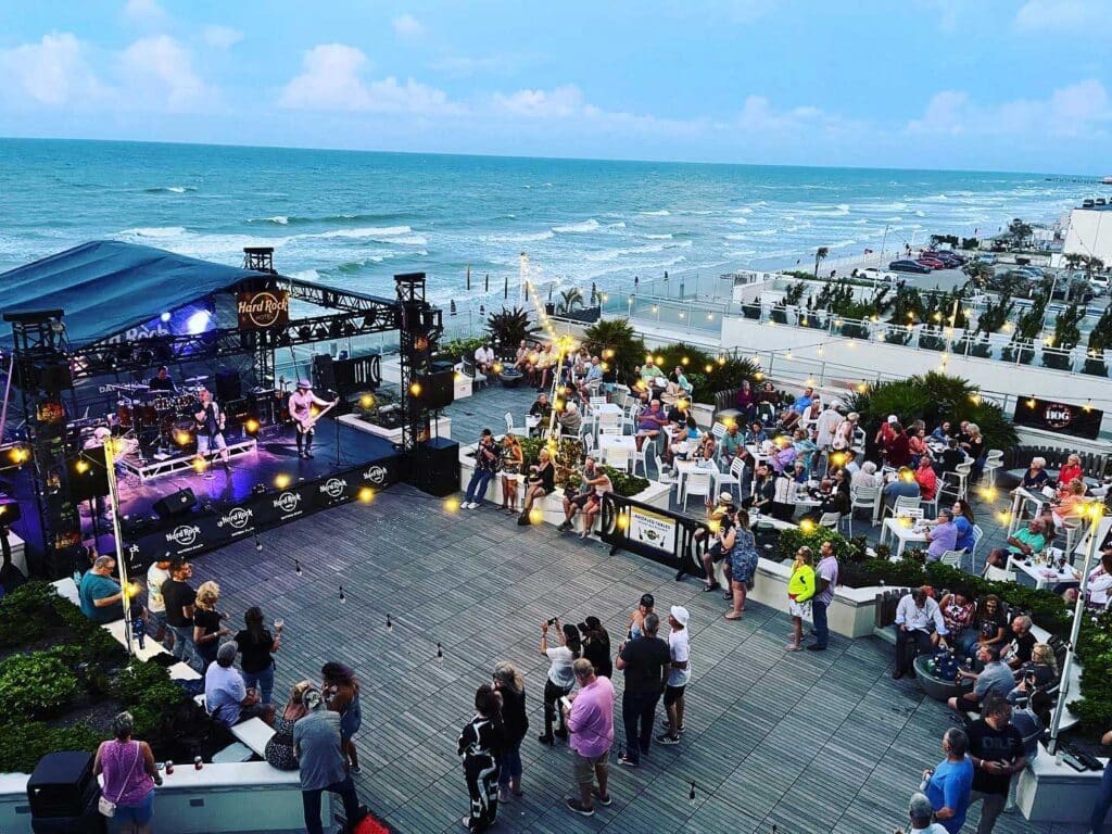 A band performs outside by the beach