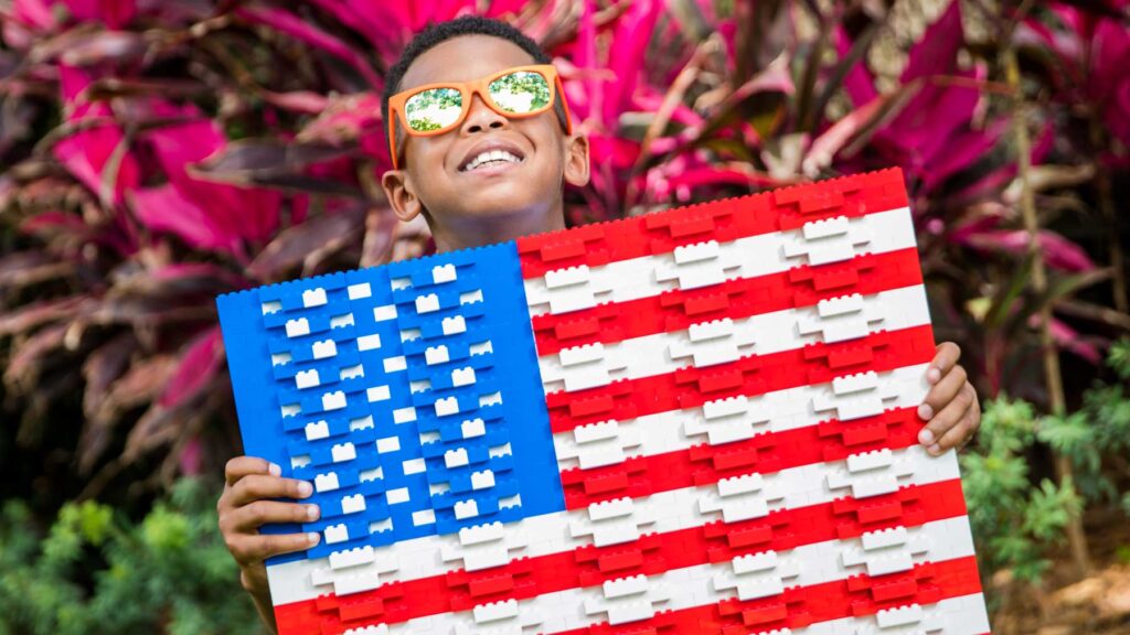 Boy holding a Lego brick flag