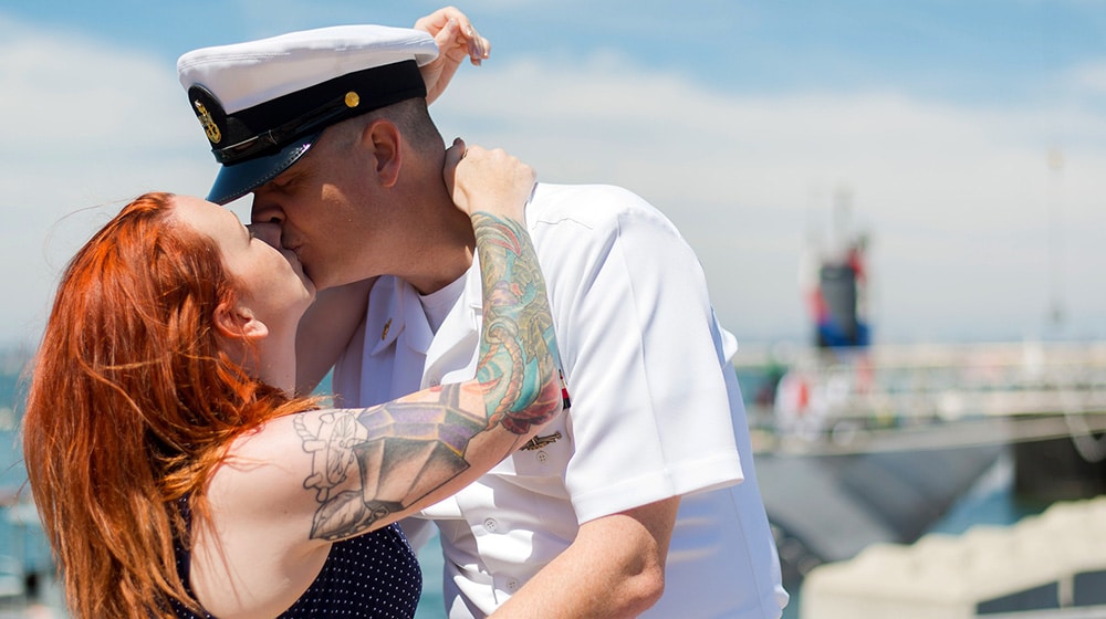 A Navy man kissing a woman