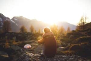 Girl sitting alone at campsite